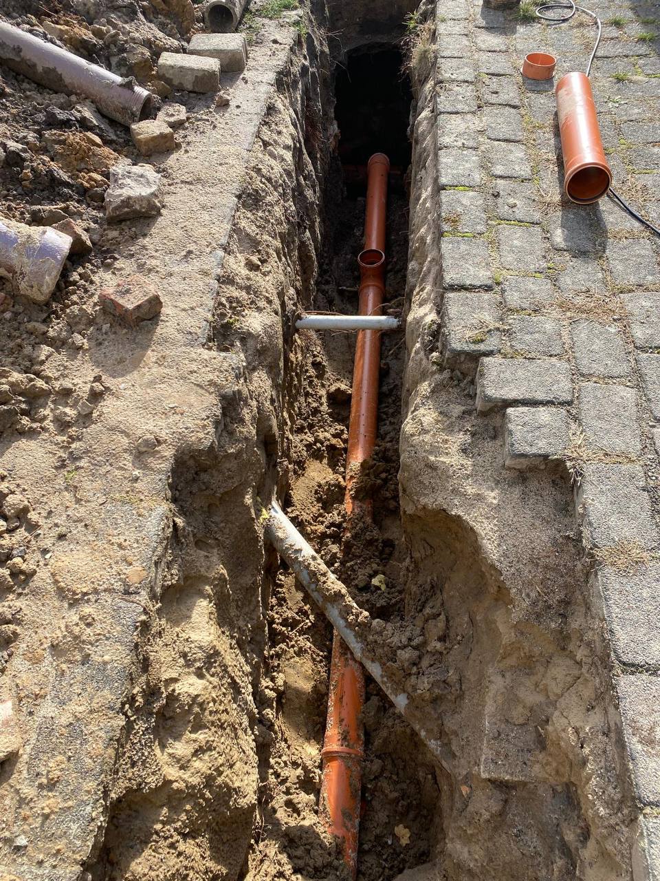 Graben mit Rohrleitungen im Boden