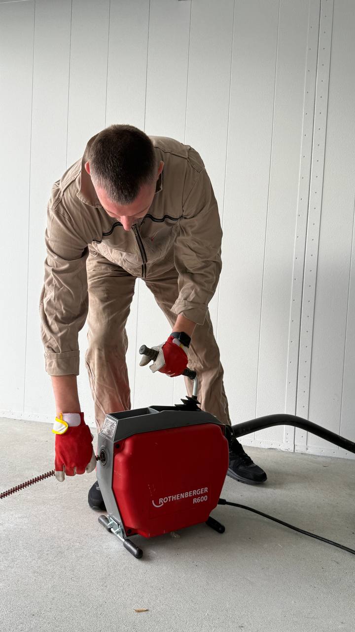 Mann bedient eine Maschine im Raum.