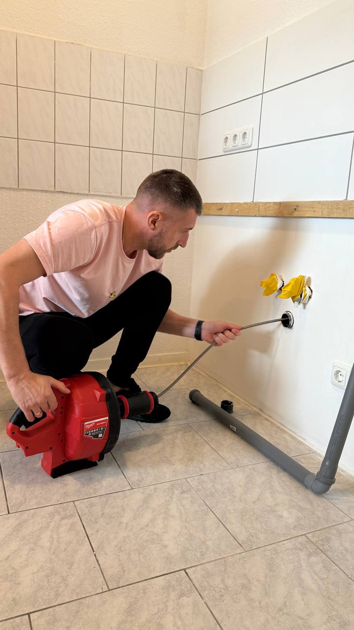 Mann reinigt Wand mit Gerät